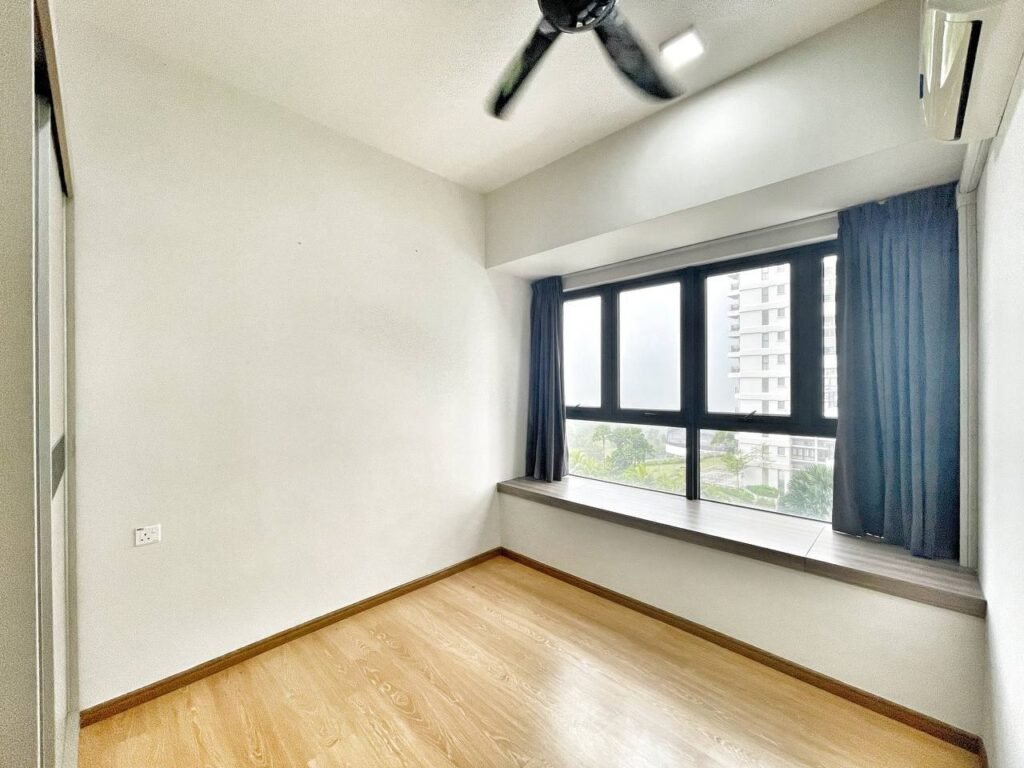 Empty bedroom with wood-look flooring, window seat, and city or garden view.