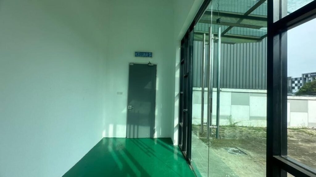 Interior corridor beside glass frontage looking toward the exterior yard