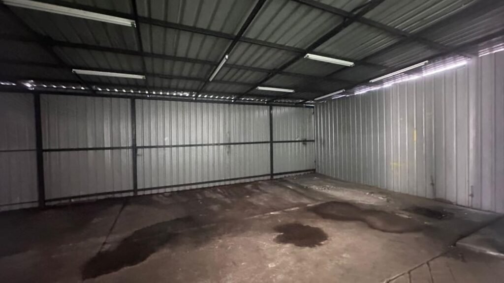 Empty industrial bay with metal wall panels and roof structure