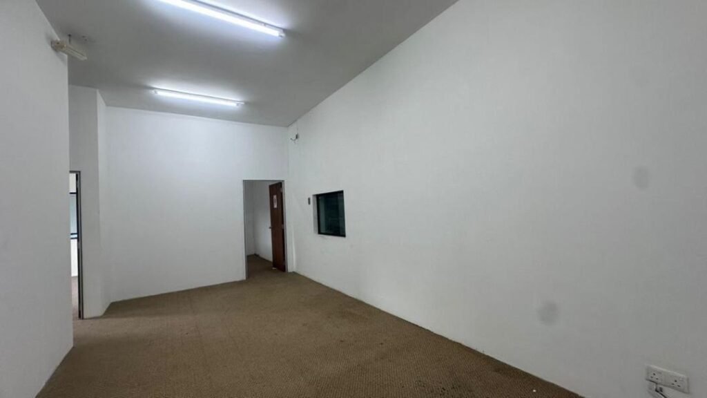 Interior room with white walls, fluorescent lights, and a doorway