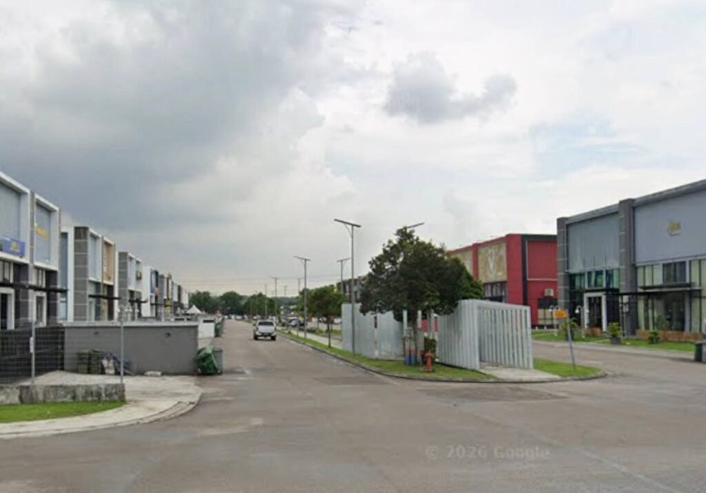 Street view showing rows of industrial units along a road