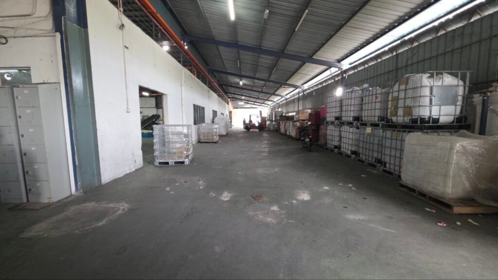 Long covered industrial corridor with stored materials along the side