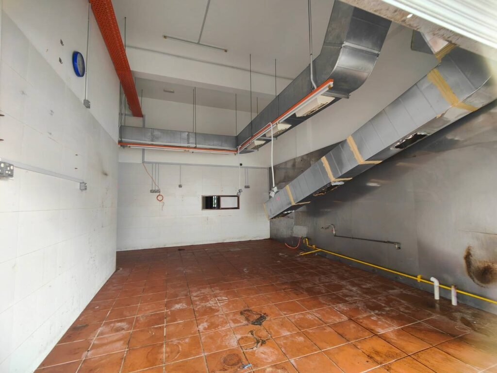 Interior view of a commercial shop/office unit with tiled floor and visible ceiling ducting.