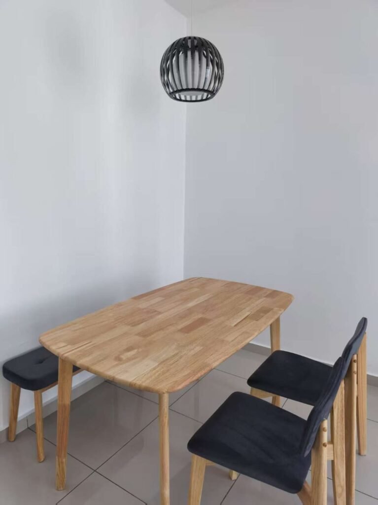 A compact dining area with a wooden table and chairs in a bright room.