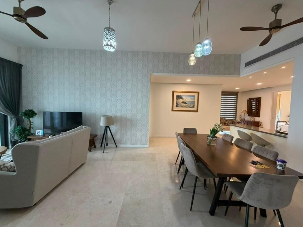 Spacious living and dining area with sofa, dining table, and decorative lighting.
