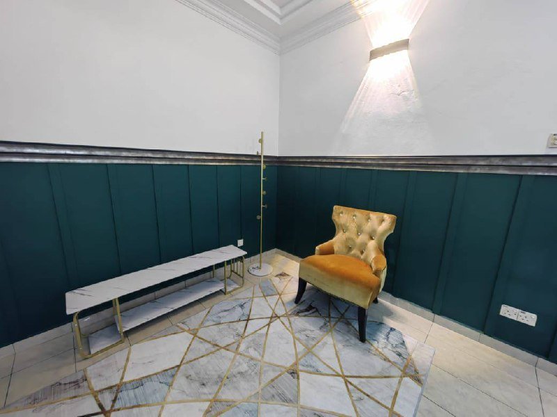Small furnished indoor sitting area with accent wall and chair.