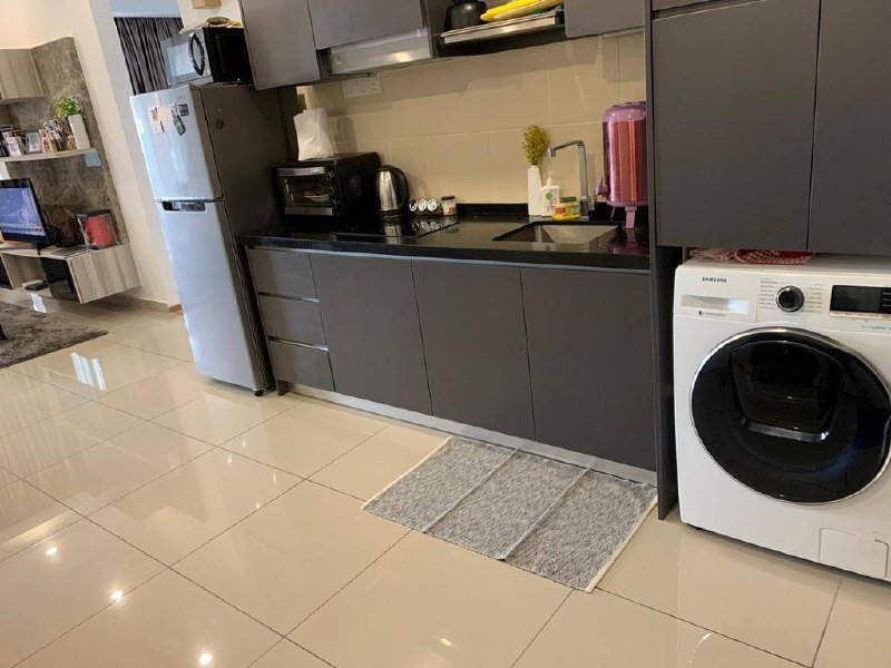A compact kitchen area with built-in cabinets, countertop appliances, and a washing machine.