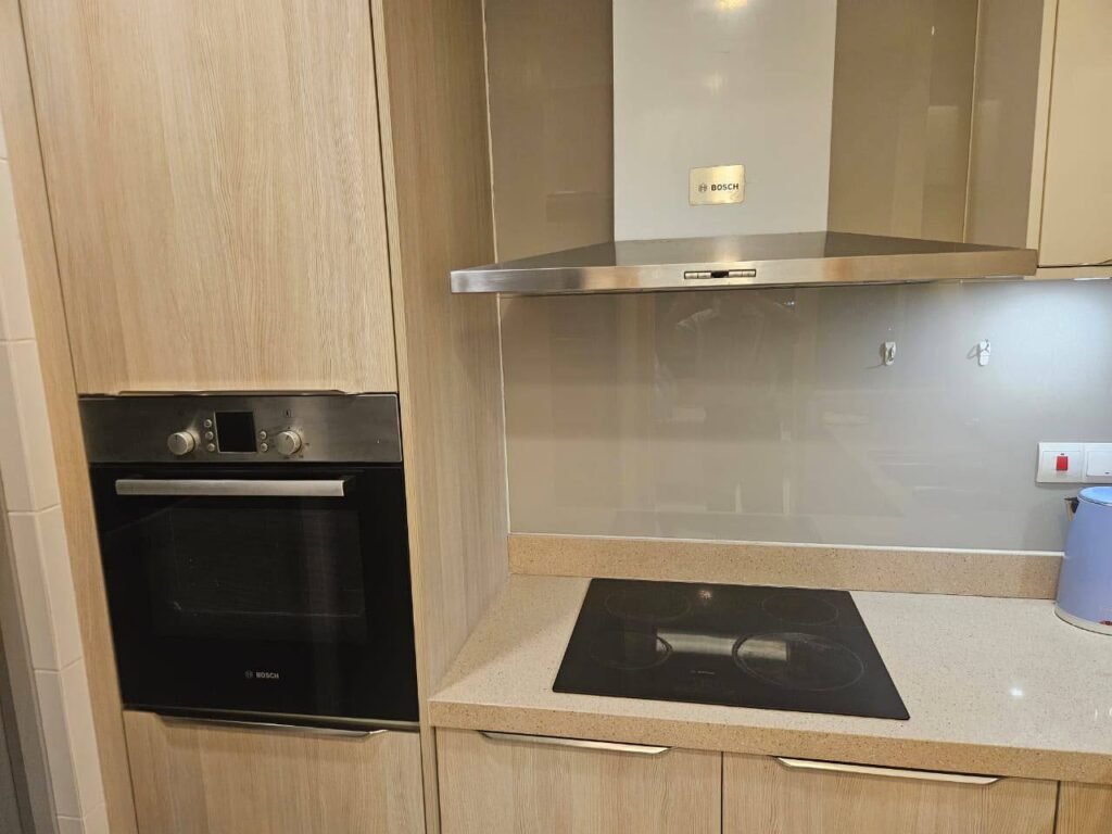 A built-in kitchen with oven, hob and range hood.