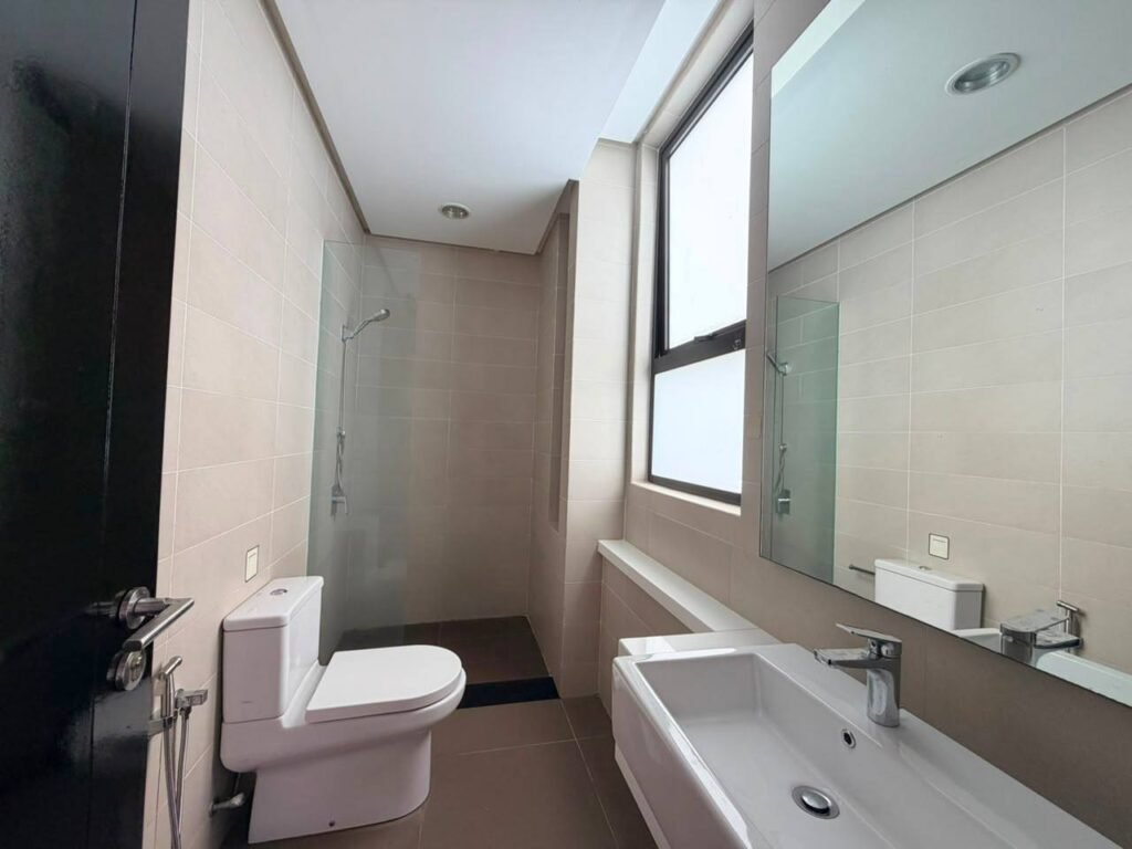 Modern bathroom with shower area, toilet and vanity sink