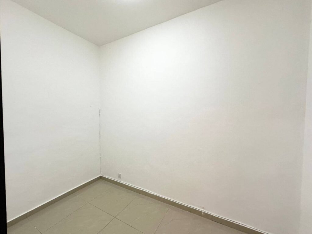 Empty interior room with tiled floor and plain white walls.