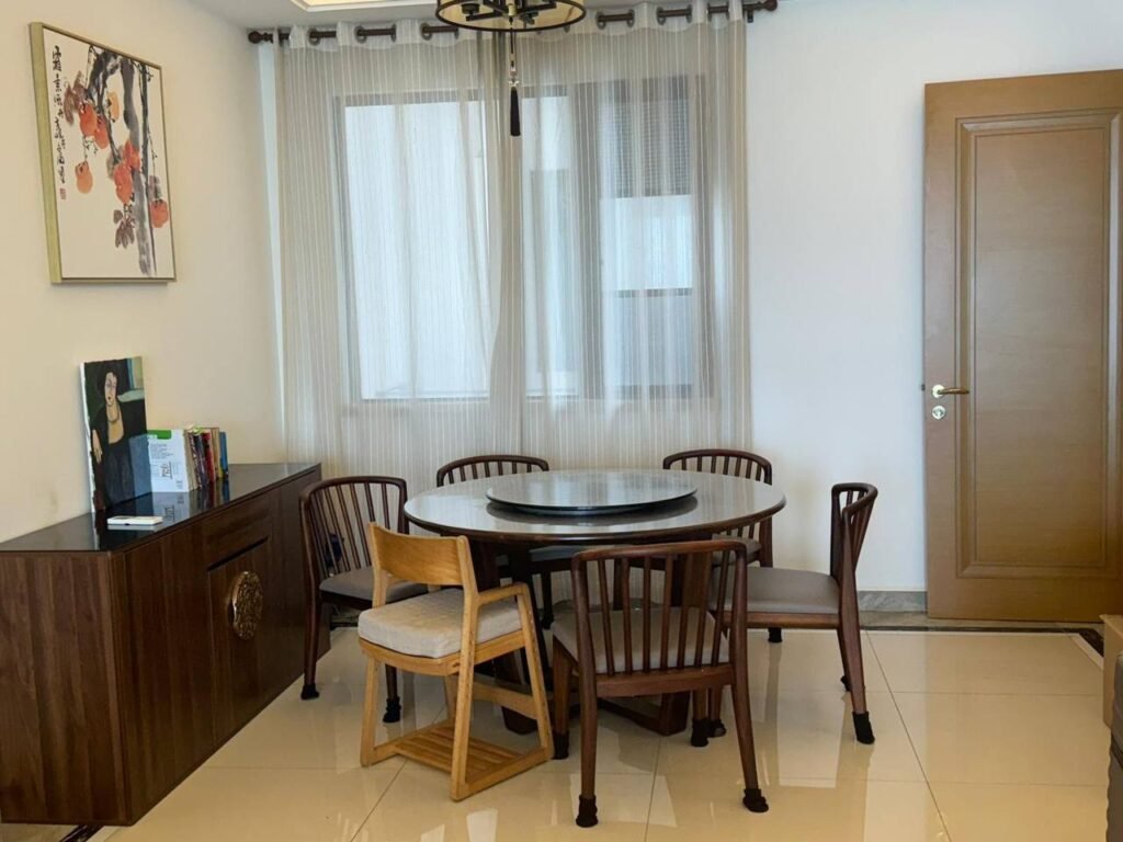 Dining table with chairs beside a window and door