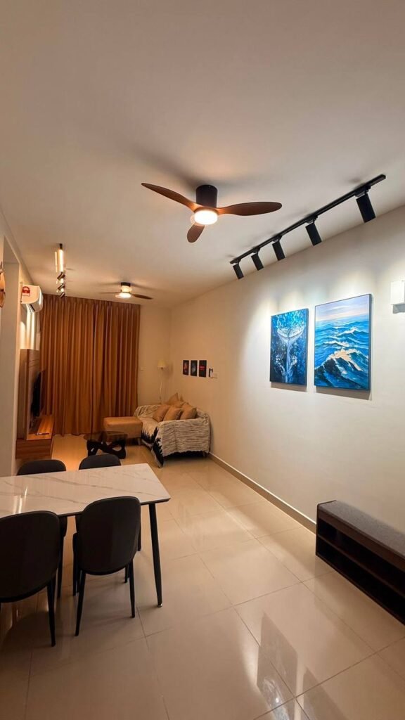 Open-plan living and dining area with sofa, dining table, wall art, and ceiling fans