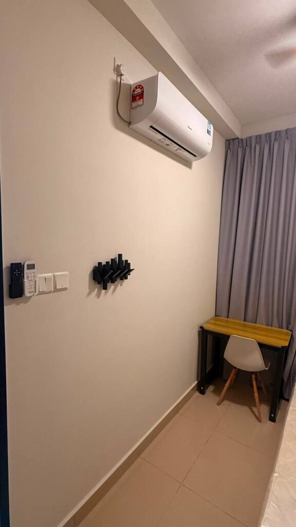 Bedroom corner with desk, chair, curtains, and wall-mounted air conditioner
