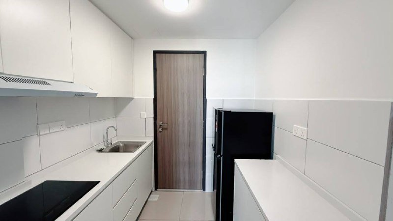 Compact kitchen with cabinets, countertop, sink and refrigerator.
