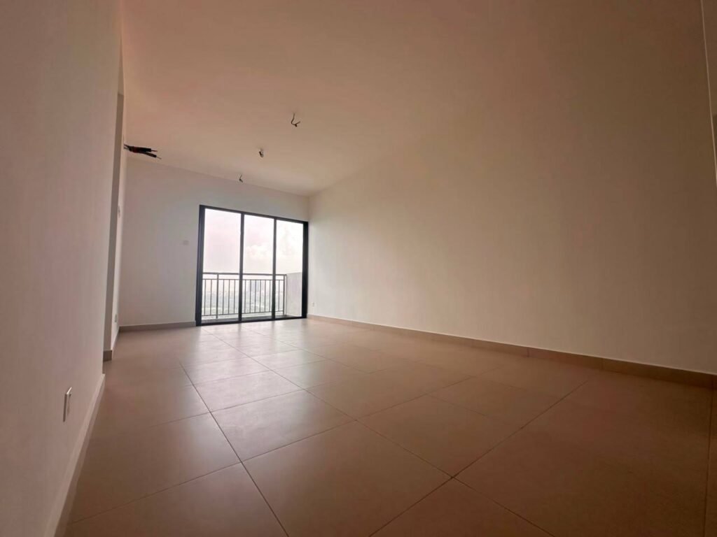 Spacious empty living room with balcony access and city view.