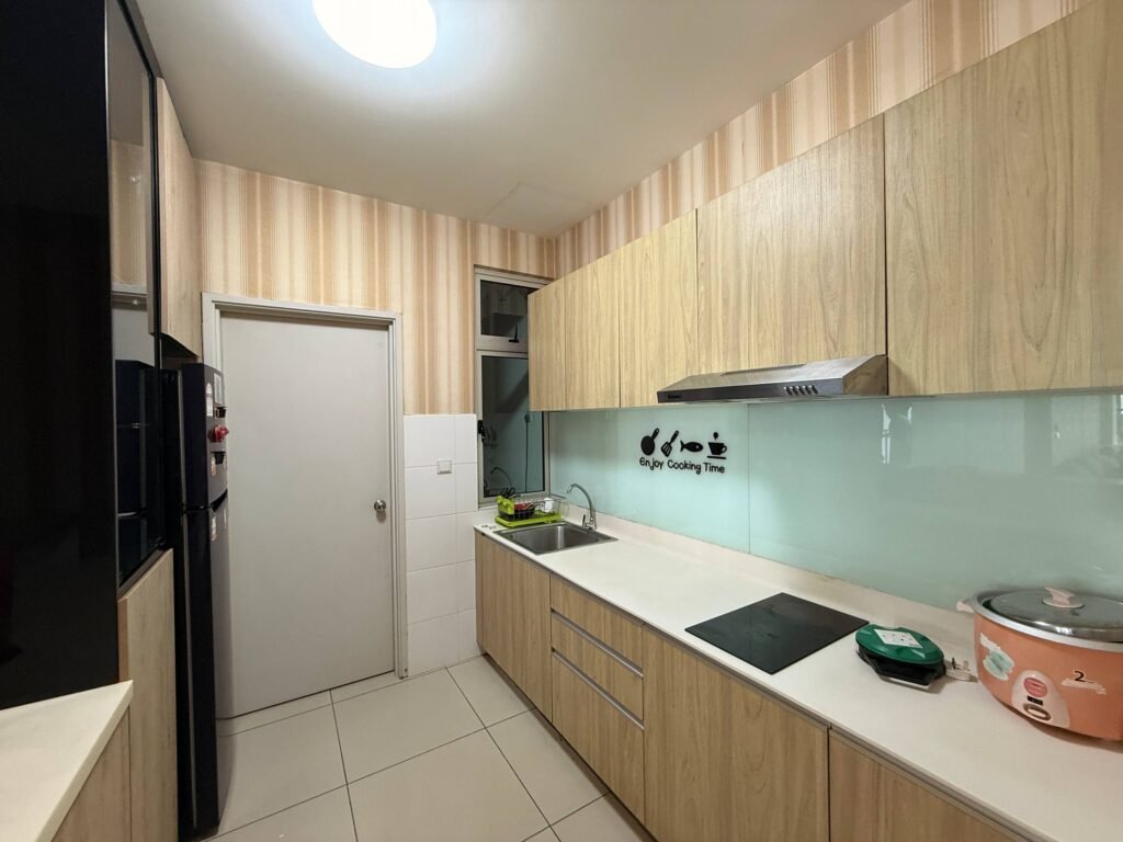 A narrow galley kitchen with light wood cabinetry, white countertop, sink, cooktop, and glass backsplash.