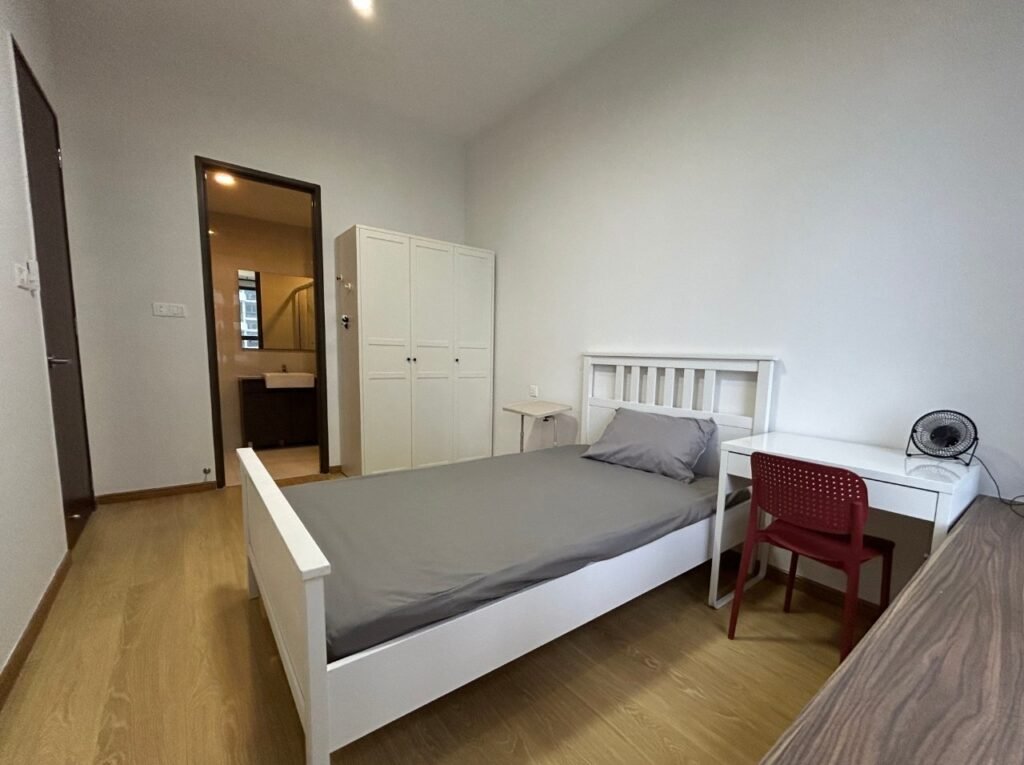 A bright bedroom with a bed, wardrobe, desk, and wall art.