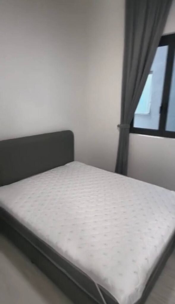 Bedroom with bed frame, mattress, and window with curtains.