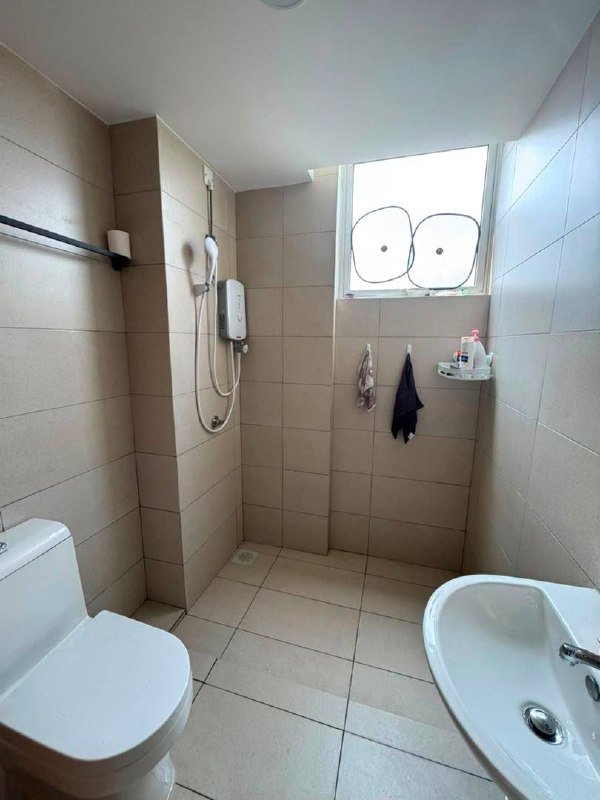 Bathroom with shower area, toilet and sink.