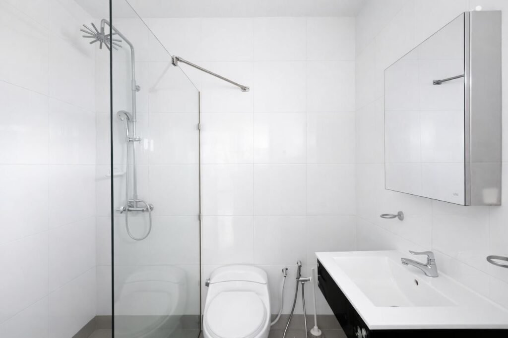 Modern bathroom with shower, toilet, sink, and mirror cabinet