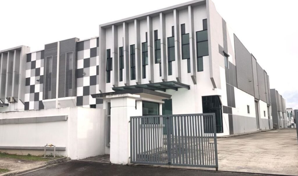 Corner exterior view of a modern industrial factory building with gated frontage