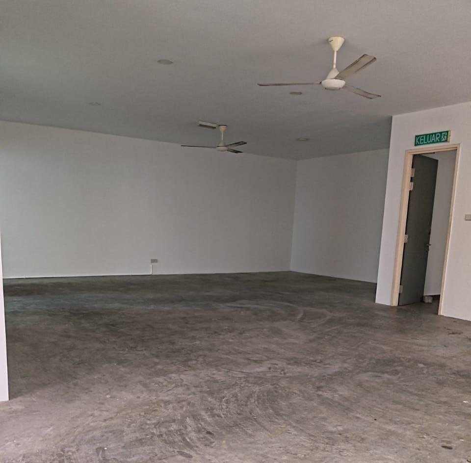 Spacious industrial interior with concrete flooring and ceiling fans.