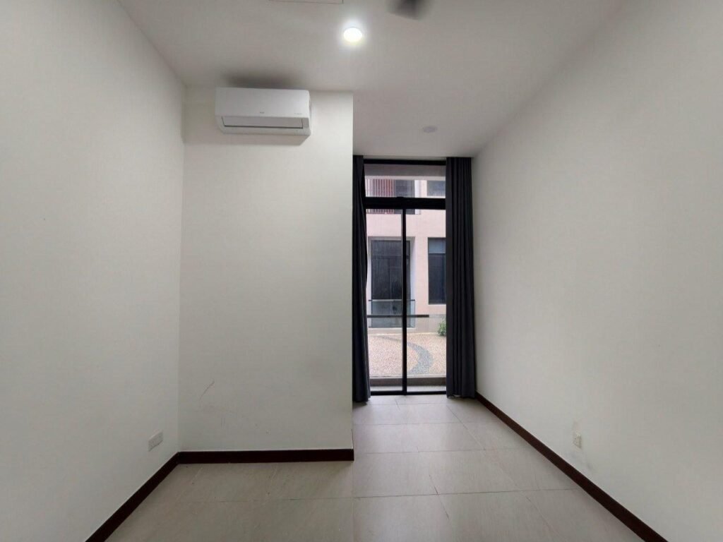 Bedroom with air-conditioner, fan, and full-height window.