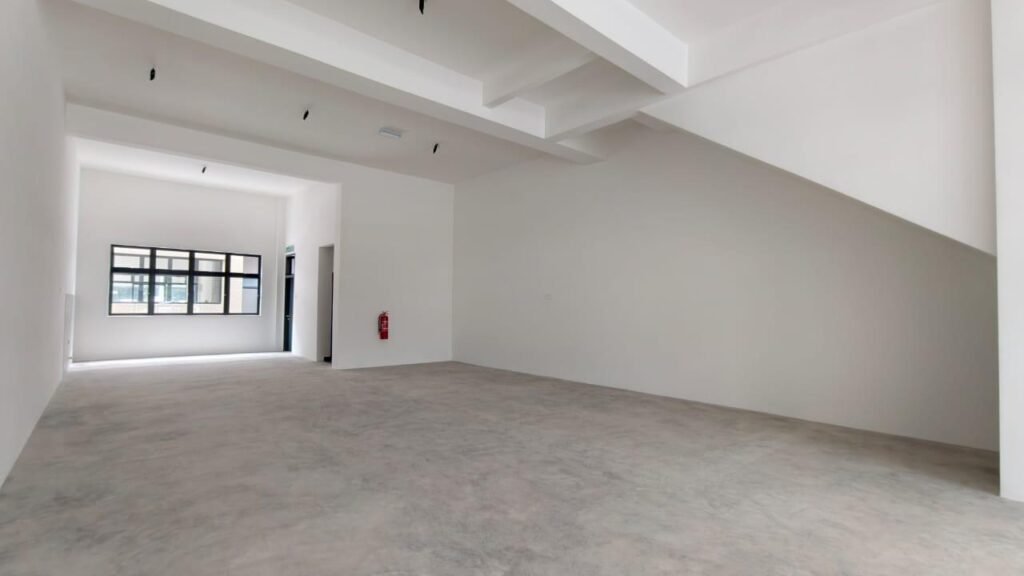 Wide empty shop space with staircase structure and rear window