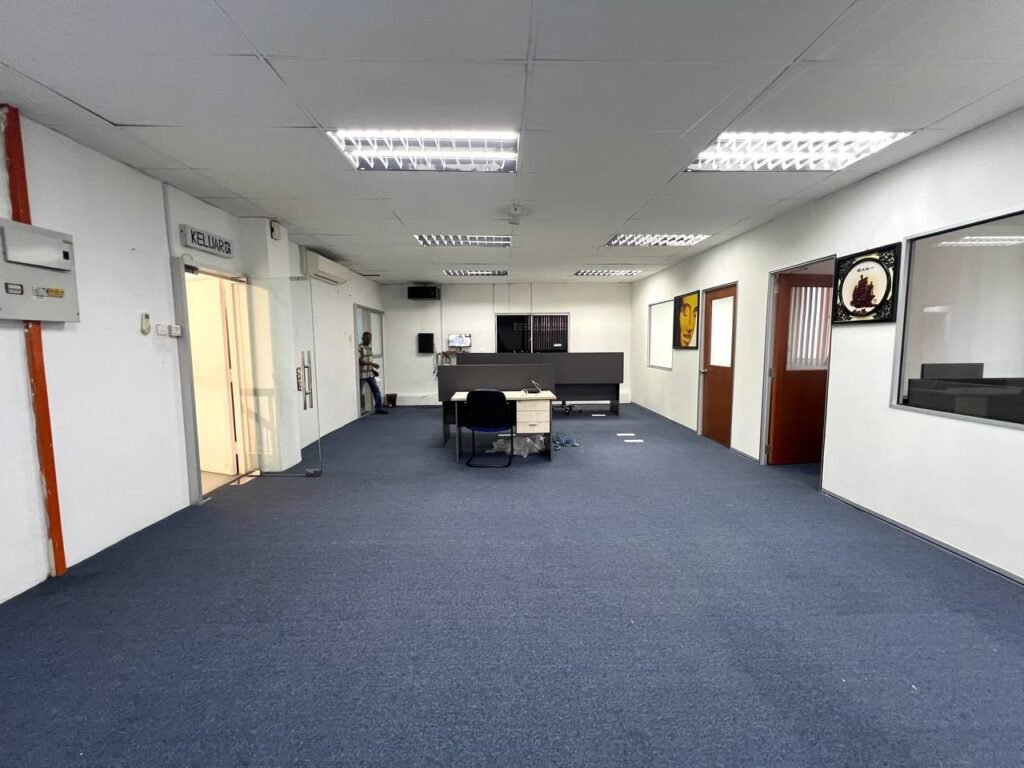 Office area with desks and partitions.