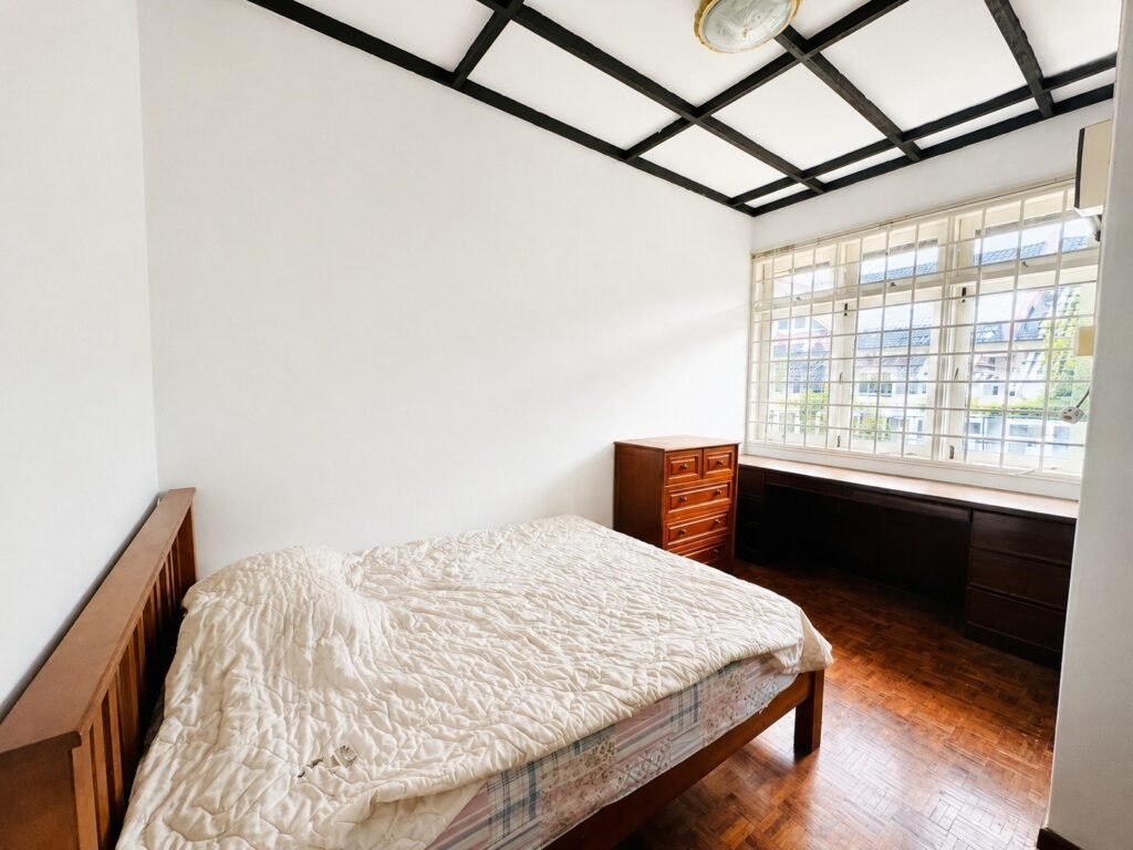 A bedroom with a bed, dresser, and window.
