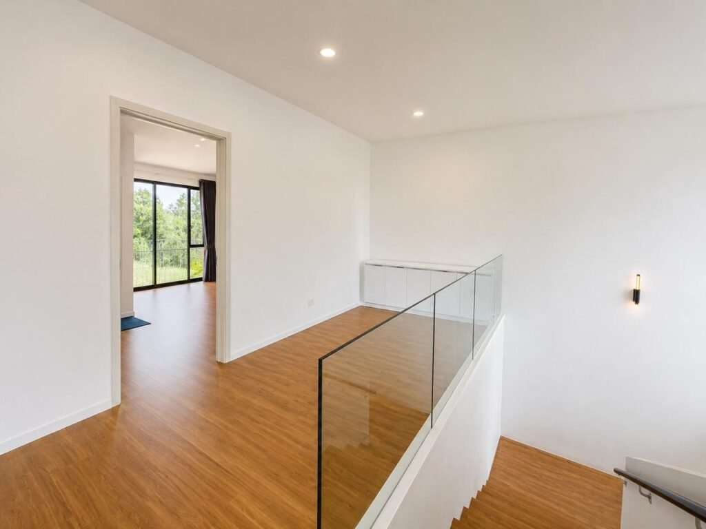 Bedroom with bathroom entrance and large window facing greenery